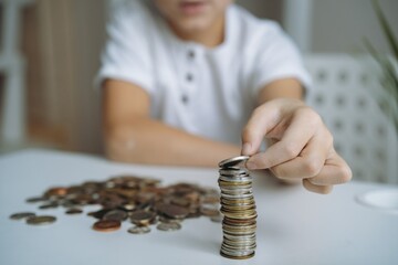 boy making pyramide of coins. ABC of finance. boy counting money