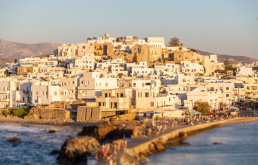 Wall Mural - Greece, Naxos harbor jetty, Cyclades islands. View from ship of  houses colored from sundown