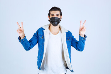 Wall Mural - Man in black mask showing enjoyment sign and feeling good