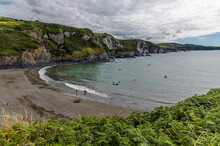 A View Across An Isolated Cove And Beach At Low Tide In North Pembrokeshire, Wales On A Summers Evening