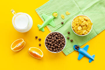 Wall Mural - Kids breakfast with corn flakes, milk and orange, top view