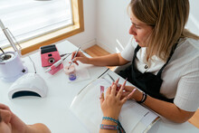 Concentrated Female Manicurist Applying Acrylic Powder On N Ails Of Client