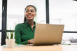 © Face Stock - Purposeful African-American businesswoman in smart casual wear sitting in modern coworking space and typing laptop, female freelancer or student with laptop computer indoors looking away