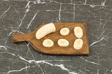 Wall Mural - Fresh banana slices on wooden board