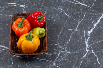 Wall Mural - Close up photo of Fresh ripe bell peppers in woven basket