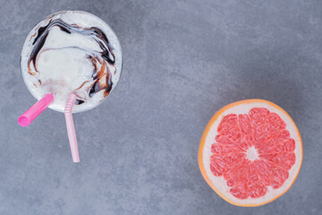 Wall Mural - Top view of Freshly made chocolate milk shake and ripe grapefruit on grey background