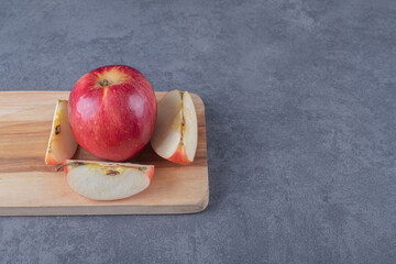 Wall Mural - Close up photo of Organic red apple on wooden board