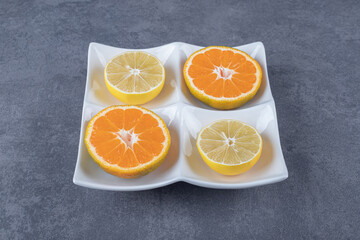 Wall Mural - Close up photo of Fresh orange and lemon slices on white plate