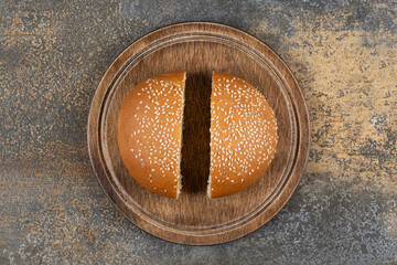 Wall Mural - Tasty bun with sesame seeds on wooden board