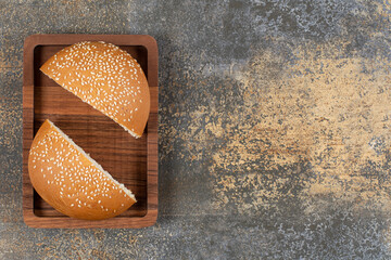 Wall Mural - Half cut tasty bun with sesame seeds on wooden plate