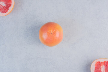 Wall Mural - Photo of whole or half cut grapefruit on grey background