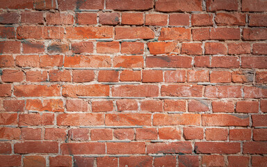 Old red brick wall grunge texture. Old cracked bricks wall with a weathered surface with with vignetted corners