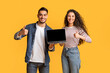 © Prostock-studio - Smiling Arab Couple Holding Laptop With Black Screen And Showing Thumbs Up