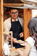 © DragonImages - Barista Giving Customer Fresh Croissant