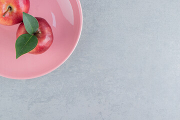 Wall Mural - Fresh apples on a pink platter on marble background