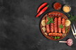Fried sausages grilled with herbs and seasonings of ketchup and mustard on a dark background.Top view with copy space,advertising for shop,cafe,menu,