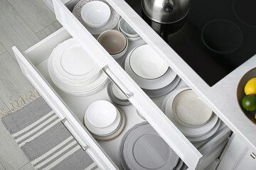 Wall Mural - Open drawers with different plates and bowls in kitchen, above view