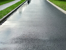 Empty New Asphalt Road On A Rainy Day. Wet Road Surface With Water Puddles After Rain.