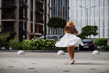 Wall Mural - Beautiful pretty woman in white dress walking at city street