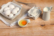 Backzutaten Eier, Milch und Mehl auf einem Küchentisch.