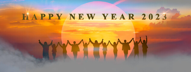 Happy new year 2023, Keep fighting together, Silhouette of 2023 letters on the mountain with business people raised arms in teamwork concept at sunrise.