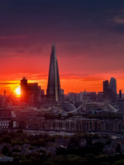  Elevated view of the London skyline during a cloudy sunset with intense red colors and sunlight during autmn time, England