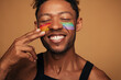 © kegfire - Happy black man painting LGBT flag on face