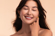 Smiling ethnic woman touching face in studio