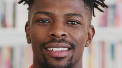 Poster - African man, smile and happiness while showing white teeth while standing in a college library with shelves in South Africa. Face portrait of a male student with a happy and positive mindset in life