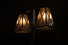 Two Retro Style Lamps With Bright Yellow Light Against The Dark Night Background. Vintage Outdoors Lantern.