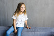 © F8  \ Suport Ukraine - Small little girl sitting on a comfortable sofa in the family room
