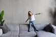 © F8  \ Suport Ukraine - Adorable small little girl jumping at home on sofa