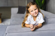 © F8  \ Suport Ukraine - Portrait of smile little girl laying on couch