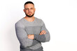 © oleg_ermak - Friendly young man in gray knit sweater cross hands on breast. Copy space white background. Autumn-winter clothing collection