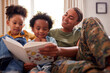 Army Mother In Uniform Home On Leave With Children Reading Book On Sofa Together