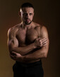 © oleg_ermak - Portrait of a handsome muscular bodybuilder posing over warm dark background. Naked muscular torso, chest, biceps and abs