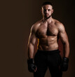 © oleg_ermak - Studio portrait of fighting muscular man in black fighting gloves posing on dark background. The concept of mixed martial arts. Brutal bodybuilder energy and power boxing.