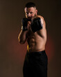 © oleg_ermak - Studio portrait of fighting muscular man in black fighting gloves posing on dark background. The concept of mixed martial arts. Brutal bodybuilder energy and power boxing.