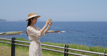 Woman Take Photo On Cellphone Beside The Sea