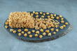 Caramel coated cake and a bunch of caramel popcorns on a board on marble background