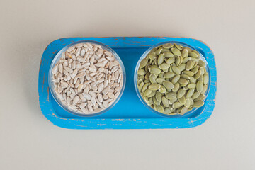 Wall Mural - Sunflower and pumpkin seeds in a blue platter