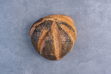 Wall Mural - Single loaf of black sesame coated bread on marble background