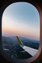 City Behind Plane Window At Sunset