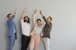 © Studio Romantic - Team of happy excited people celebrating success. Group portrait of four confident coworkers, teammates and business partners standing in studio and giving each other high five. Teamwork concept