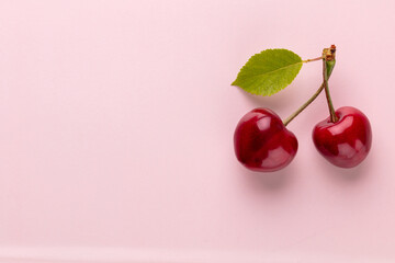 Wall Mural - Cherry berries on a pastel background top view.  Background with a cherry on a sprig, flat lay