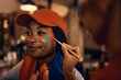 © Drazen - Black soccer fan getting her face painted in colors of her favorite team during world championship.