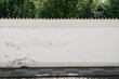 © Bonsales - Long old concrete wall covered with white plaster at city street. Cement fence exterior with copy space and mockup.