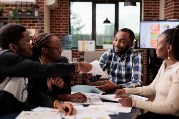 Wall Mural - team of colleagues analyzing business documents in startup office, meeting to do teamwork collaborat