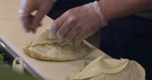 Close-up Shot Of Chef Making A Pita Bread Sandwich Behind A Restaurant Counter.