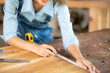 © EKKAPON - Carpenter working on woodworking machines in carpentry shop. woman works in a carpentry shop.